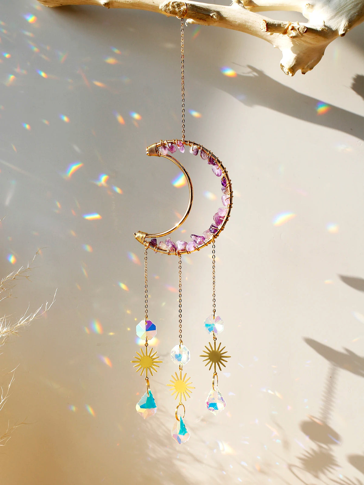 A handcrafted moon crystal suncatcher featuring a gold crescent and purple crystals with dangling prism beads.