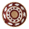 Round woven straw wall decor hanging featuring concentric rings of reddish-brown, white, and tan fibers.