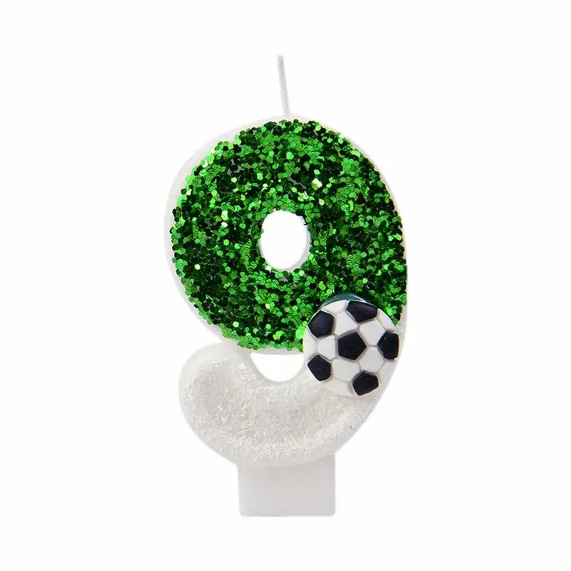 A number zero candle decorated with green glitter and a soccer ball shape.
