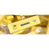 Un jouet anti-stress en forme de banane jaune visible dans un emballage en plastique transparent.