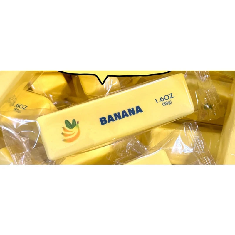 Un jouet anti-stress en forme de banane jaune visible dans un emballage en plastique transparent.