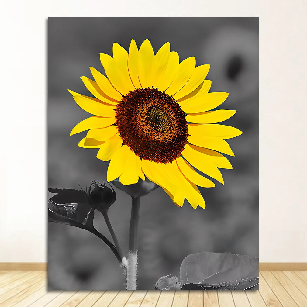 A close-up photograph of a bright yellow sunflower against a gray, blurred background.