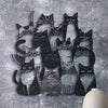 A collection of black cats in various poses and styles displayed as metal wall art on a gray textured background.