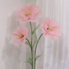 A large artificial silk pink poppy flower arrangement displayed on a green stand against a white background.