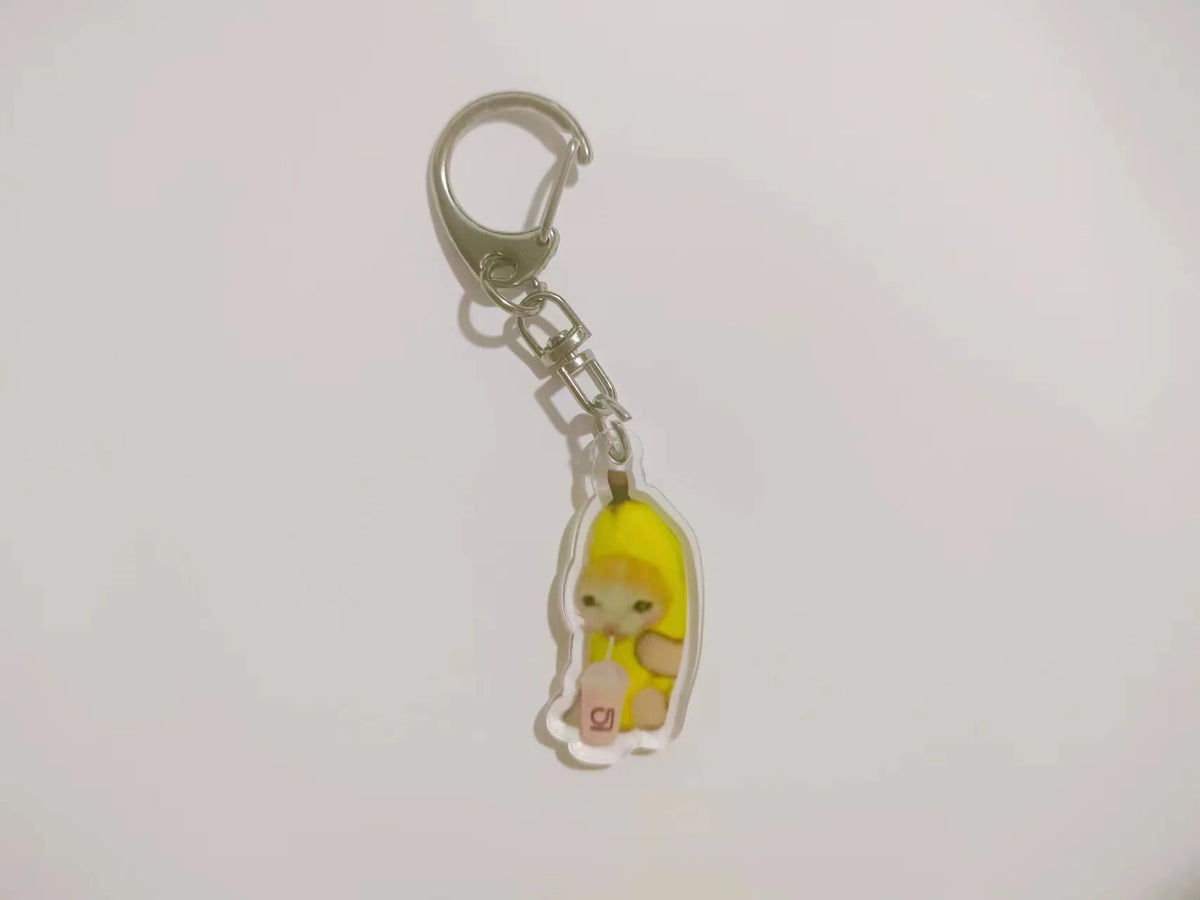 Acrylic keychain featuring a yellow banana cat charm attached to a silver split ring.