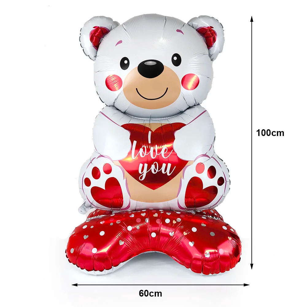 A large white teddy bear balloon with a red heart design and 'love you' text, accompanied by a red heart foot balloon.