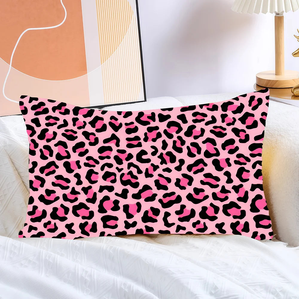 A pink leopard print decorative pillow cover lying on white bedding.