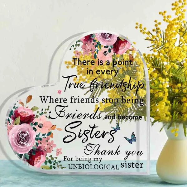 Plaque en acrylique transparent au cœur avec motif floral et texte disant : Il y a un sens à chaque vraie amitié où les amis 