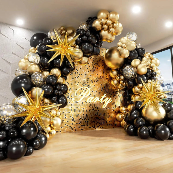 An elegant balloon garland arch featuring black and gold balloons with starburst foil accents.