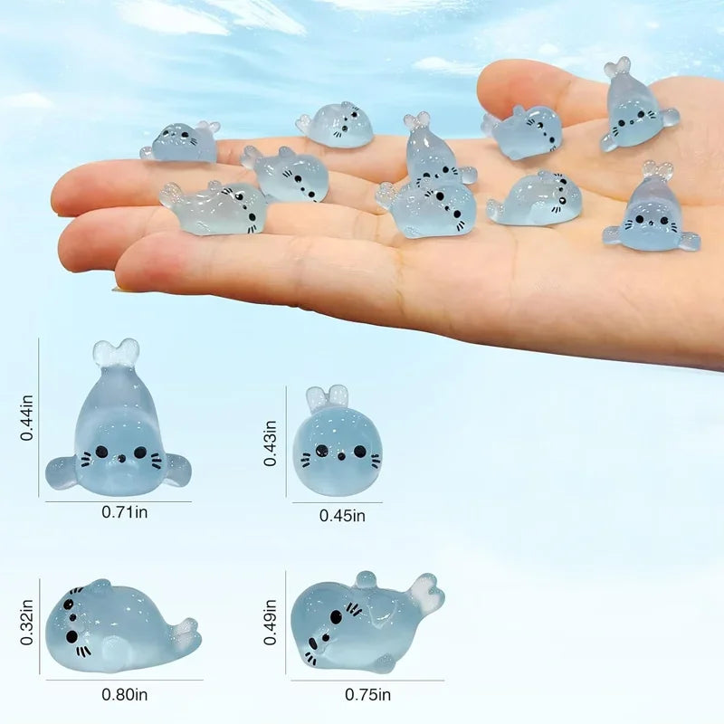A hand holds a collection of translucent blue glow in the dark resin sea animal figurines.