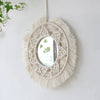 Miroir rond en macramé pour la décoration murale, avec une couronne de fibres naturelles et un miroir accroché sur un mur bla