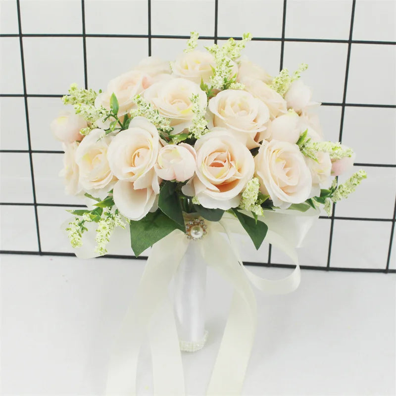 Elegant white silk rose bridal bouquet with green foliage tied with a sheer ribbon