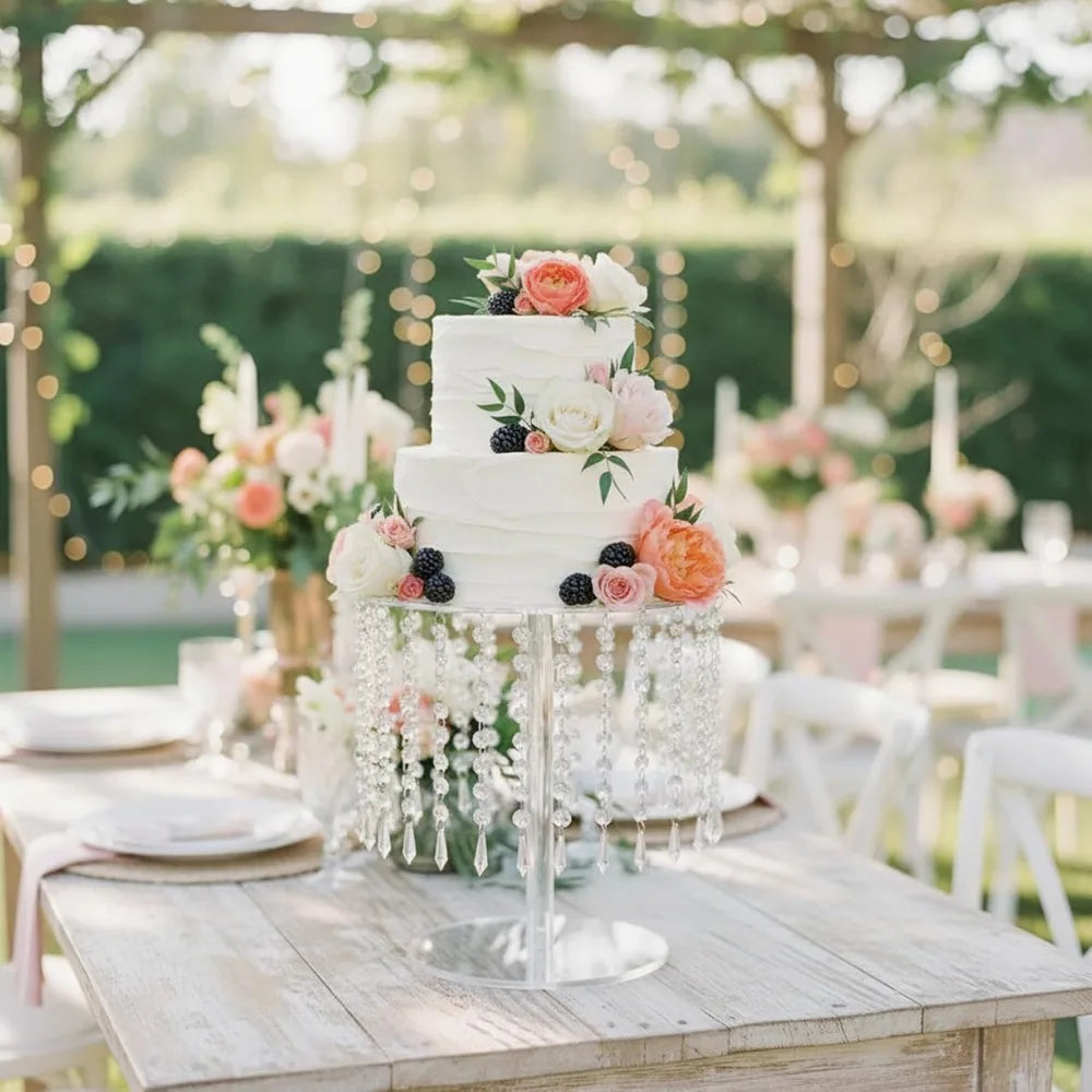 A tiered white cake display rack featuring a wedding cake decorated with pink and orange floral accents on a rustic wooden ta