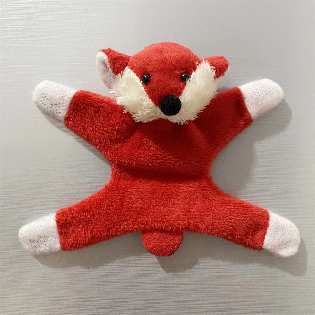 A plush fox-themed fridge magnet featuring bright orange fur and white accents.