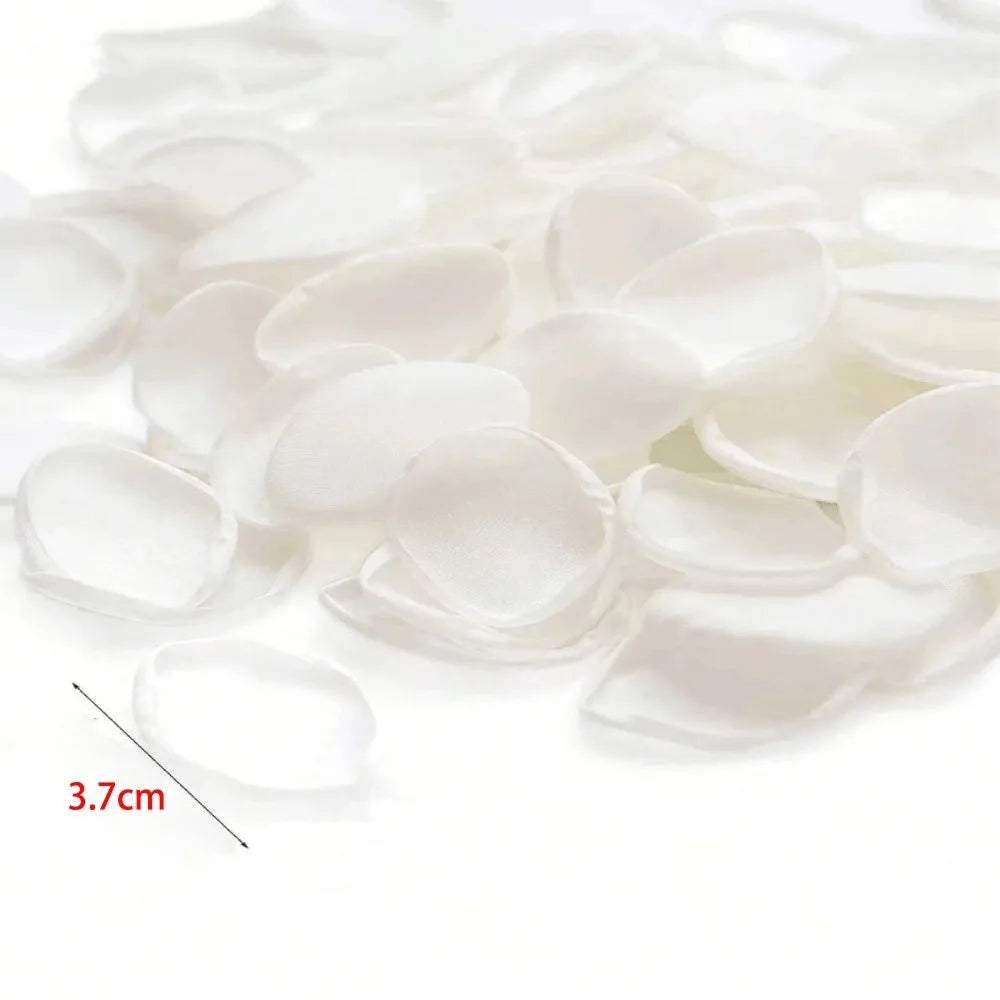 Pétales de roses de soie artificielle blanche éparpillés sur un fond blanc.