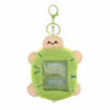 A cute, light green, round keychain featuring a smiling character and a clear plastic holder.