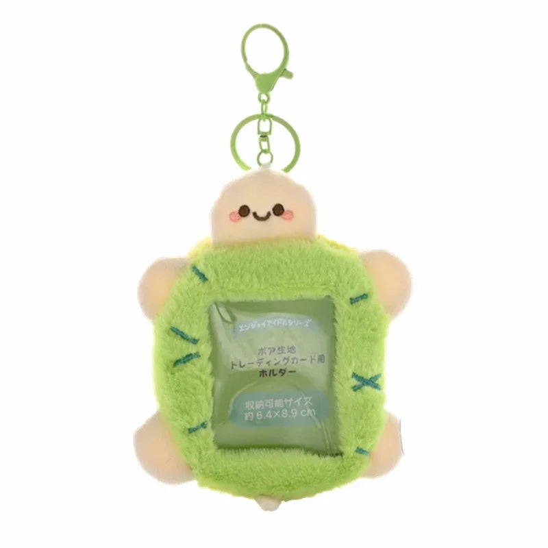 A cute, light green, round keychain featuring a smiling character and a clear plastic holder.