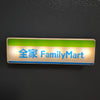 A rectangular LED sign featuring the text 全家 FamilyMart on a light background with a green border.