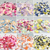 A collection of multicolor paper confetti in various shades including pink, purple, gold, blue, and white.