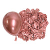A single rose gold metallic latex balloon next to a pile of crumpled rose gold metallic latex balloons.