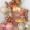 A pink and beige balloon garland arch kit featuring various sized balloons arranged in a decorative display.
