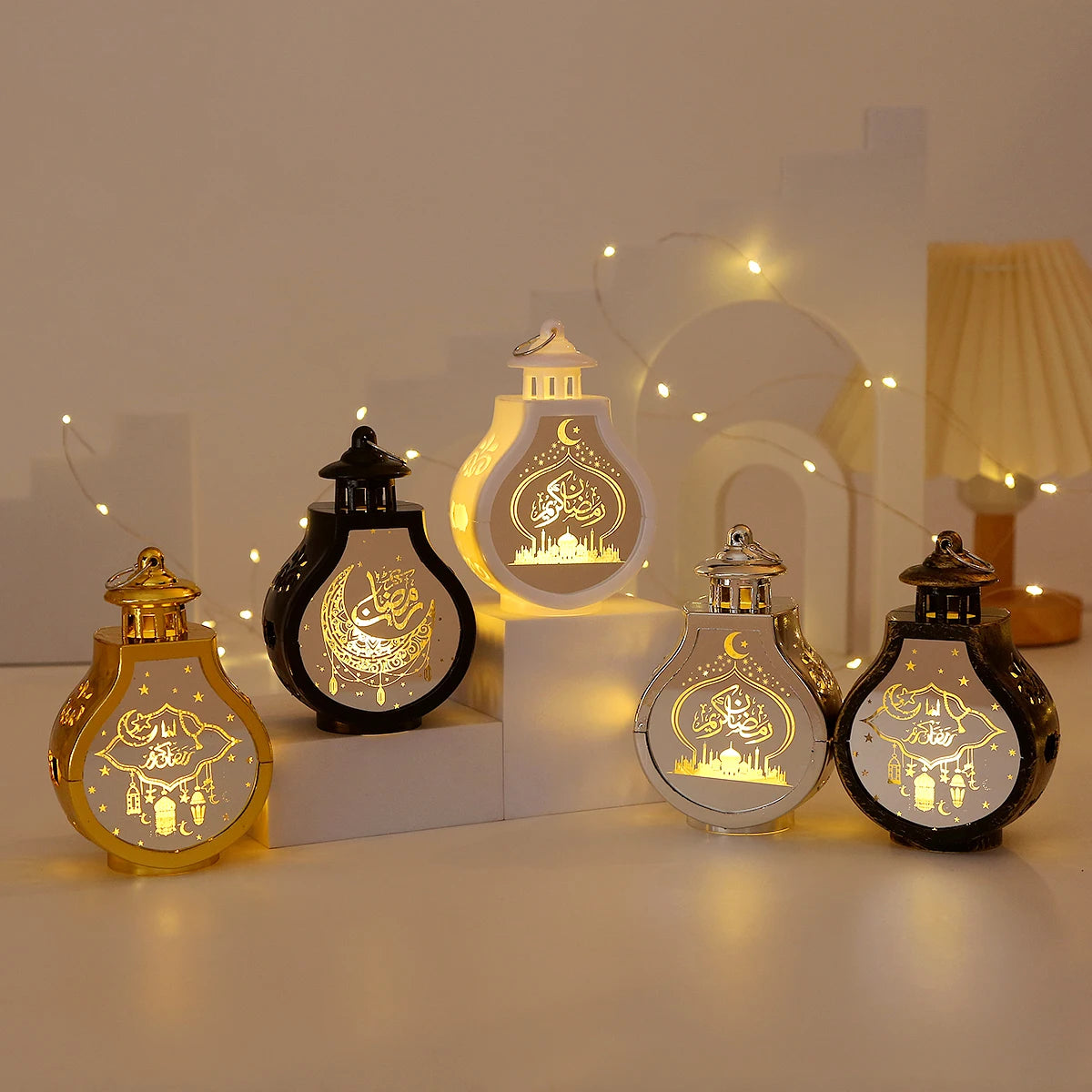 A set of elegant LED star and moon lanterns displayed on a white surface with soft lighting.