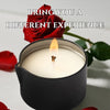 A black jar candle with a lit flame and a red rose in the background.