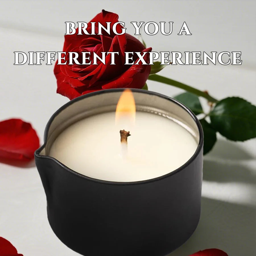 A black jar candle with a lit flame and a red rose in the background.