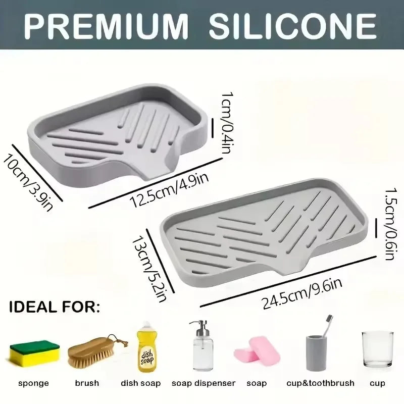 A set of gray silicone kitchen tools including a faucet splash guard, drying mat, brush, dish soap, and sponge.