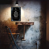 A dark metal tin sign featuring a crescent moon and text on a rustic wall with dramatic lighting.