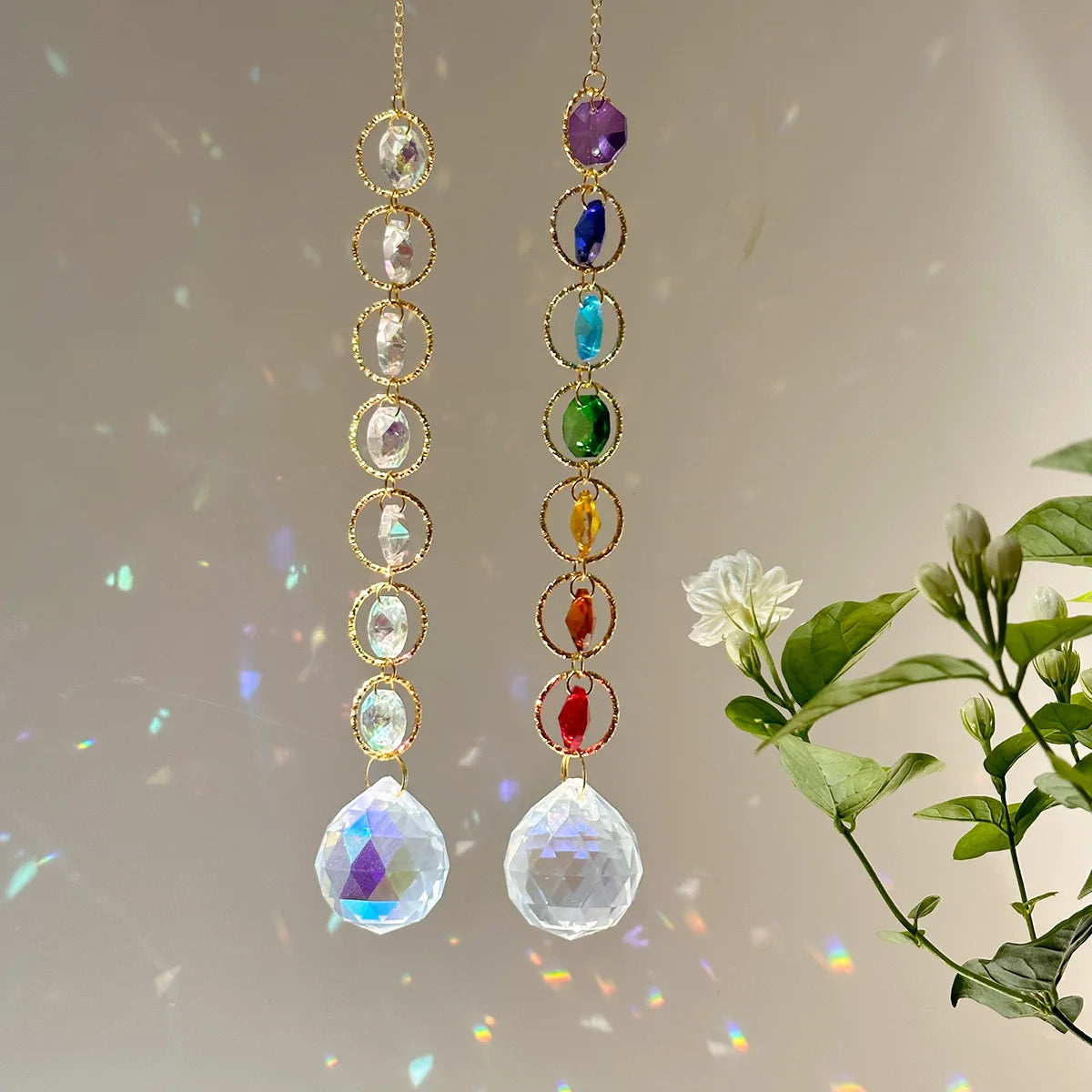 A pair of delicate gold necklaces featuring various colored crystal prisms and gemstones.