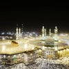 Night view of the Masjid an Nabawi in Mecca with crowds surrounding the Kaaba.