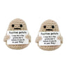 Two handmade knitted plush potato dolls with signs encouraging self-belief