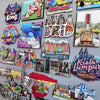 A collection of wooden fridge magnets featuring various destinations like Hong Kong, Maldives, Copenhagen, and Portugal.