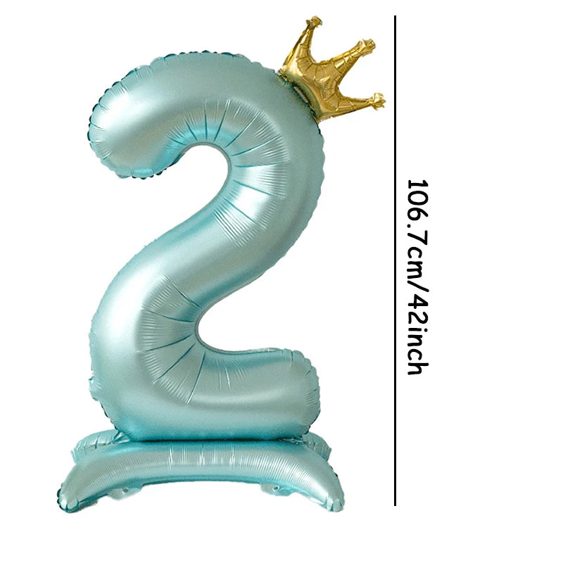 A large, light blue foil number balloon shaped like the number 2 with a gold crown topper.