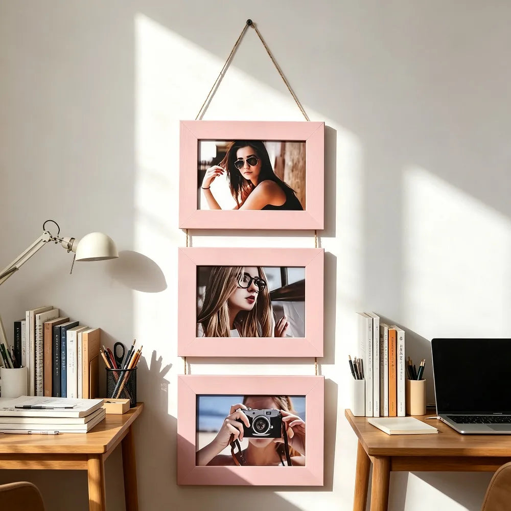 A set of three pink wooden photo frames displaying women's portraits mounted on a white wall.