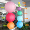 A vertical display of colorful round paper lanterns in pink, red, orange, and blue.