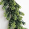 A long, green artificial pine garland draped against a white background.