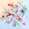 A collection of colorful mini birthday cake toppers featuring various patterns and fuzzy pom-poms.