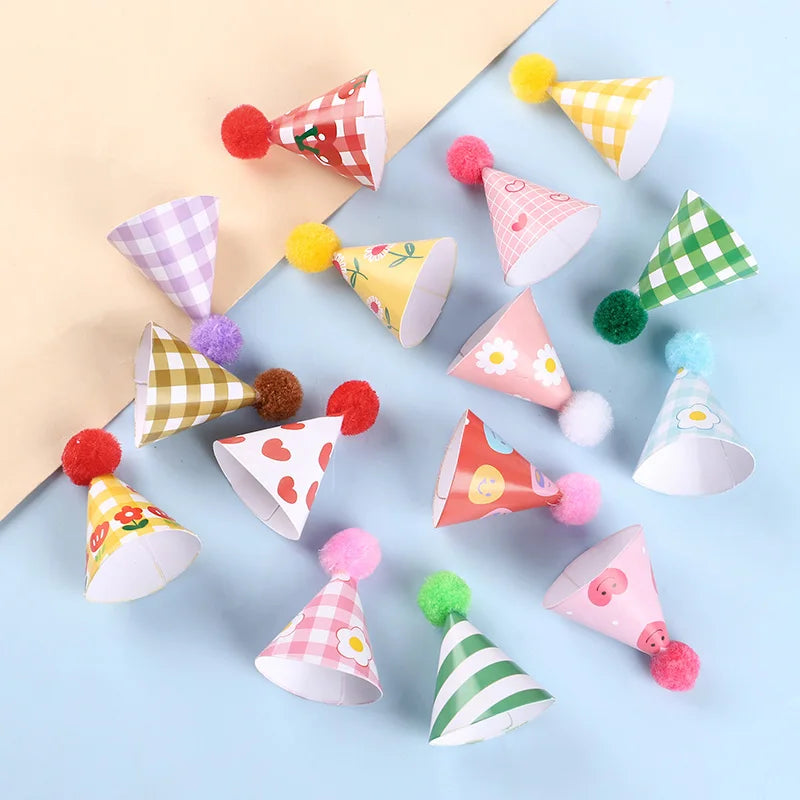 A collection of colorful mini birthday cake toppers featuring various patterns and fuzzy pom-poms.