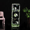 A clear glass hourglass filled with liquid sand, featuring panda figures and natural elements for desk decor.