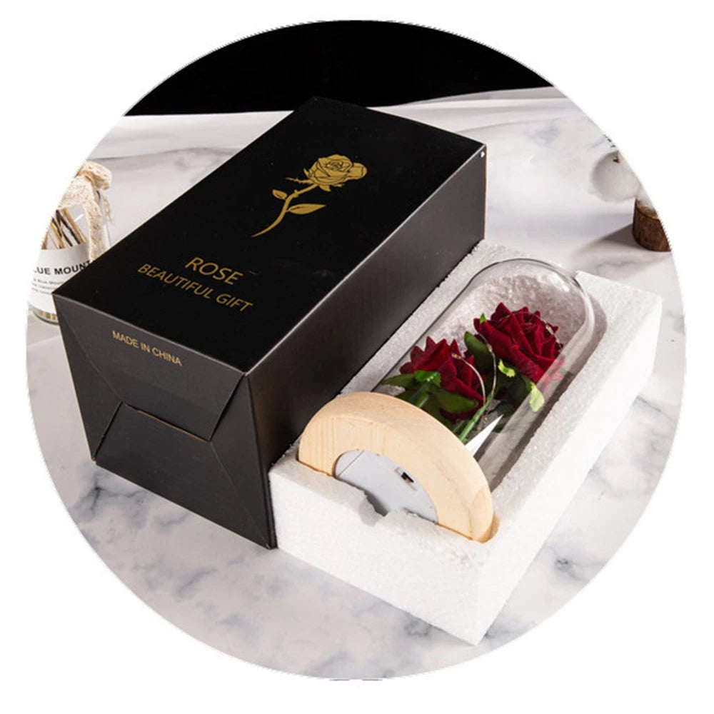 A black gift box containing an LED galaxy rose artificial flower with a glass dome, presented on a white surface.