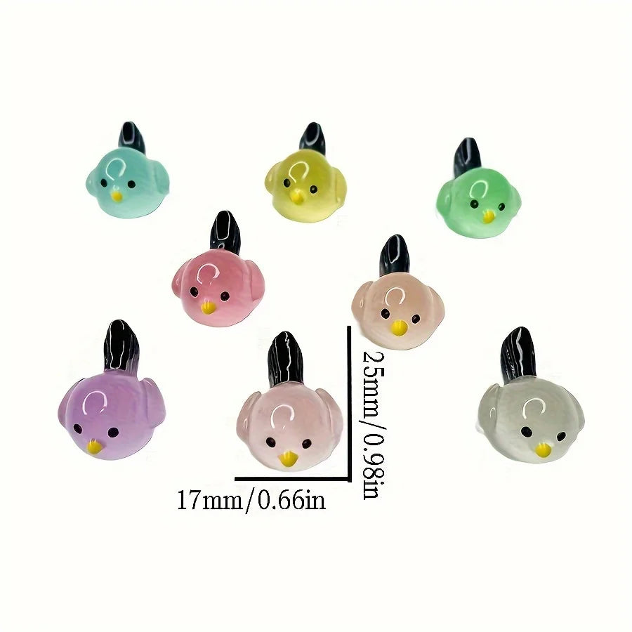 A set of five small, luminous resin bird fairy garden decor figures in various shades of green and pink.