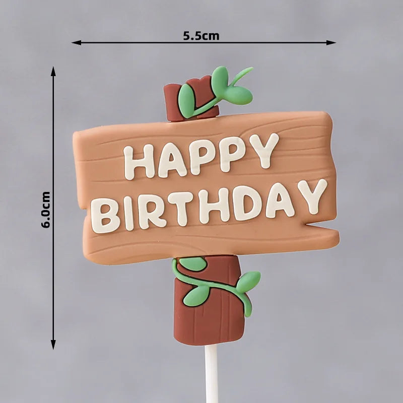 A wooden sign with 'HAPPY BIRTHDAY' written on it, decorated with green leaves and attached to a stick.