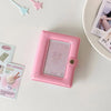 A pink compact star-shaped photo card holder album with a clear window and decorative elements is displayed on a white surfac