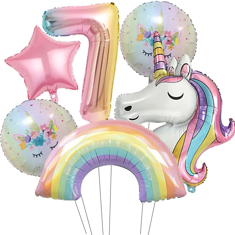 A collection of foil balloons featuring a number seven, a star, a unicorn head, and a rainbow arch.