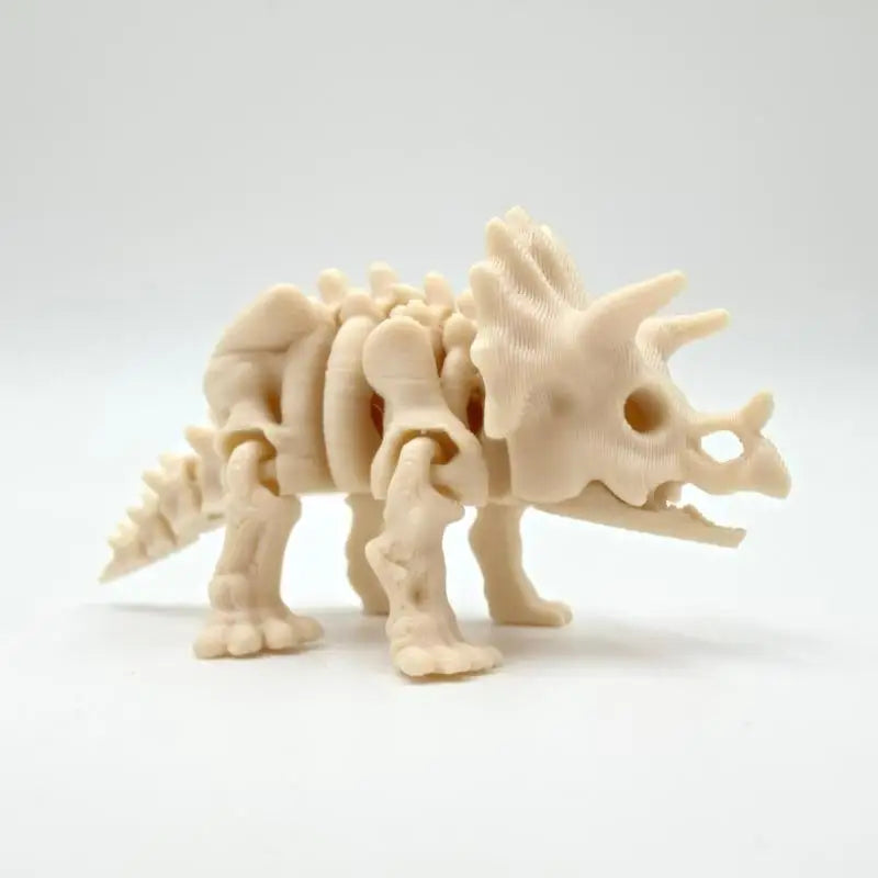 A light beige 3D printed dinosaur skeleton model for desktop display.