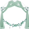 Tissu chiffon vert sauge élégant drapé en arche pour un événement.