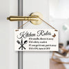 A wooden hanging sign with text listing kitchen rules such as throwing away smelly items and turning off appliances.