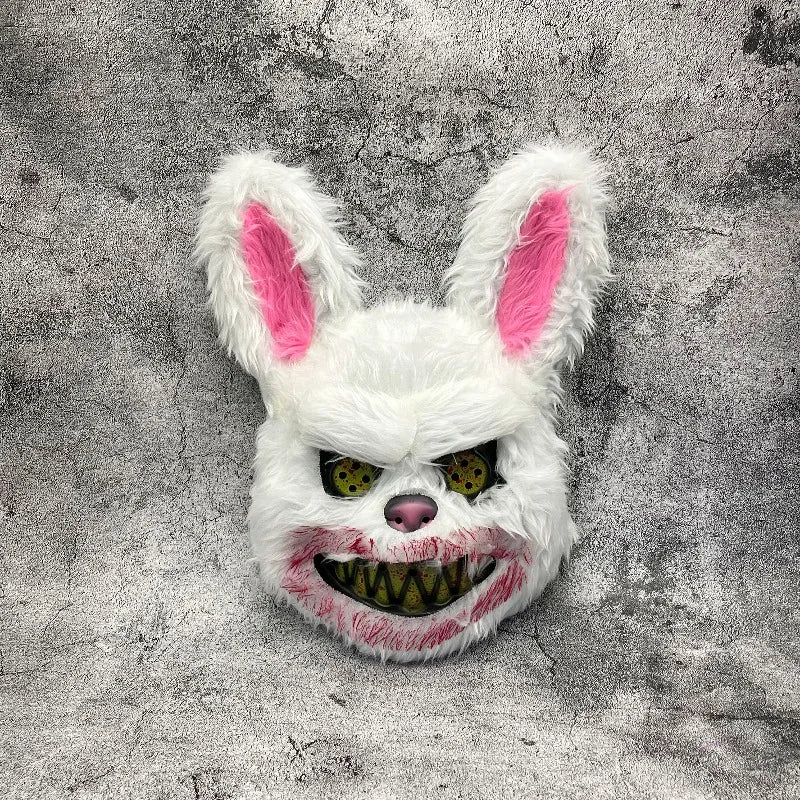 A white rabbit face mask with pink inner ears and glowing yellow eyes against a gray textured background.